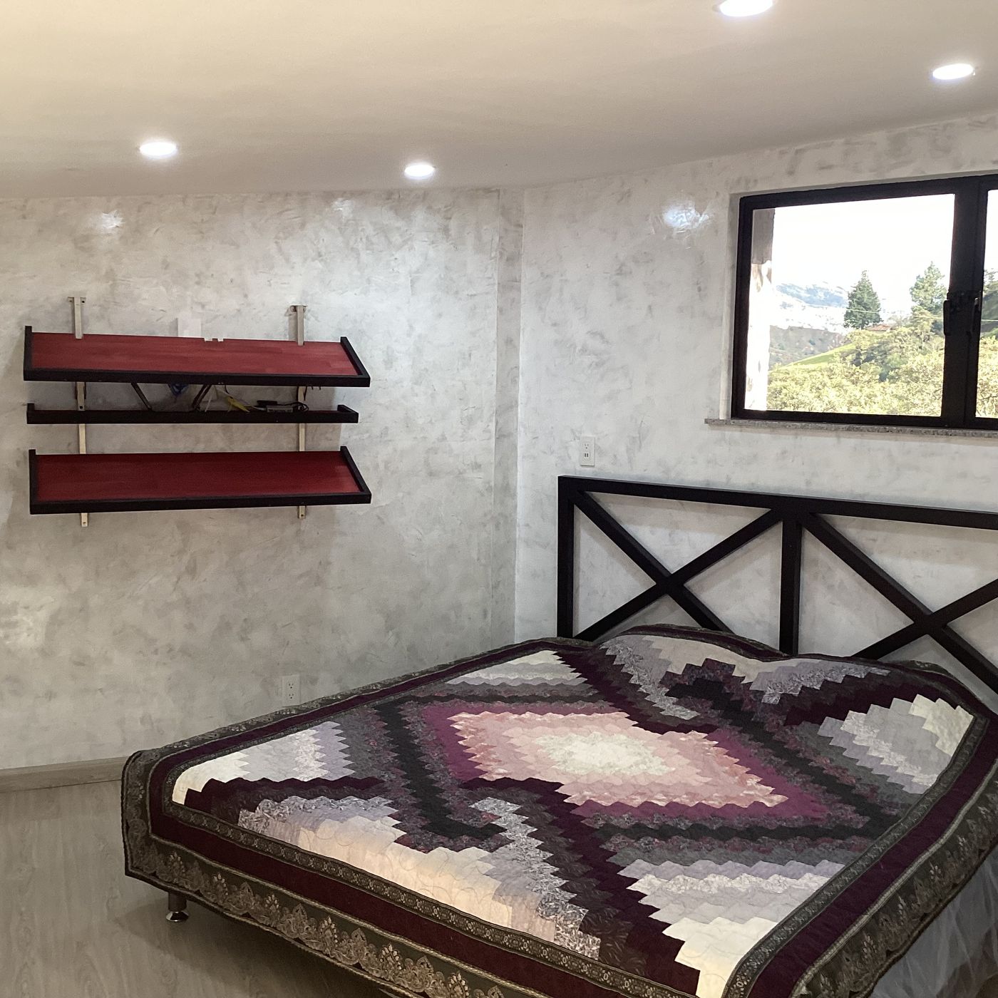 Habitación con cama y ventana hacia las montañas