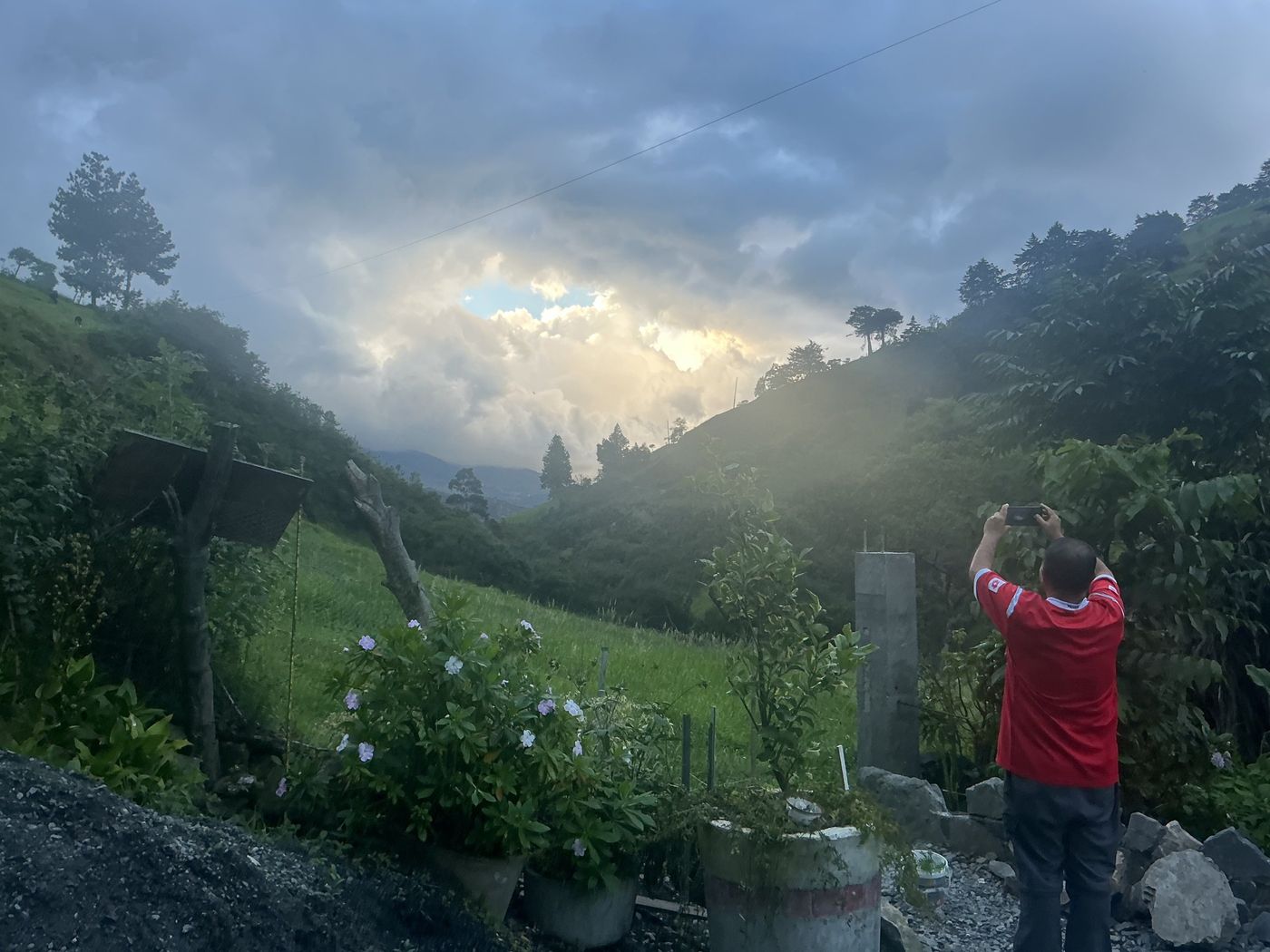 Atardecer entre nubes sobre cerros verdes